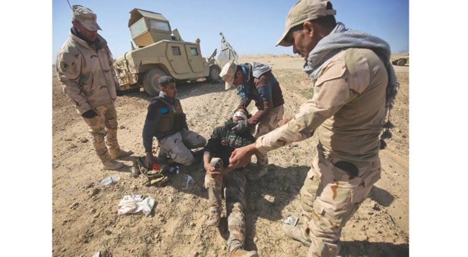 جنود عراقيون يجلون أحد رفاقهم بعدما جُرح خلال معارك جنوب الموصل أمس (أ.ف.ب)