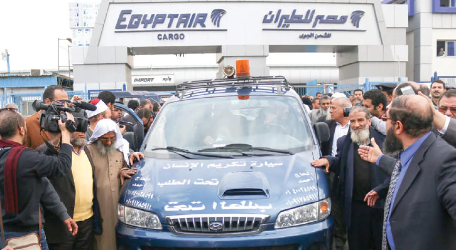 أقارب عبد الرحمن حول سيارة تحمل نعشه في مطار القاهرة أمس (أ.ف.ب)