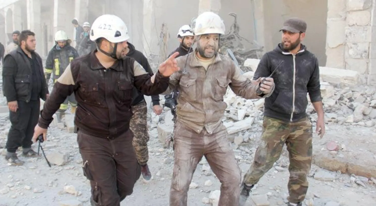 أحد أفراد الدفاع المدني (الخوذ البيضاء) لحظة قصف جوي استهدف أطراف بلدة بنّش بمحافظة إدلب التي تسيطر عليها فصائل المعارضة السورية (أ.ف.ب)