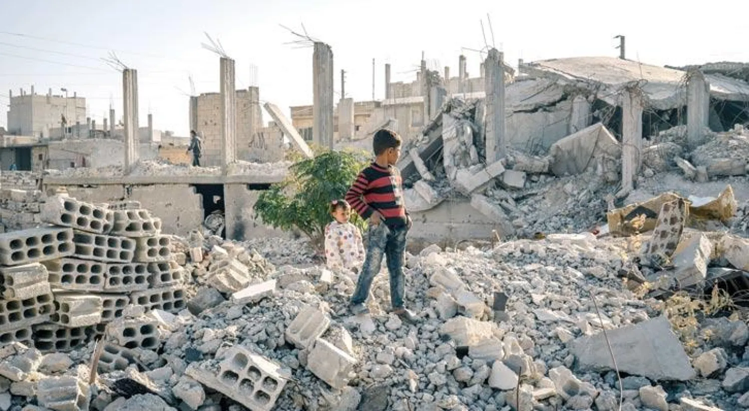 طفلان فرا من القتال الدائر بين الميليشيات الكردية ومسلحي تنظيم داعش الإرهابي في محافظة الرقة السورية يتجولان في بلدة عين عيسى بشمال المحافظة (آليس مارتنز - واشنطن بوست)