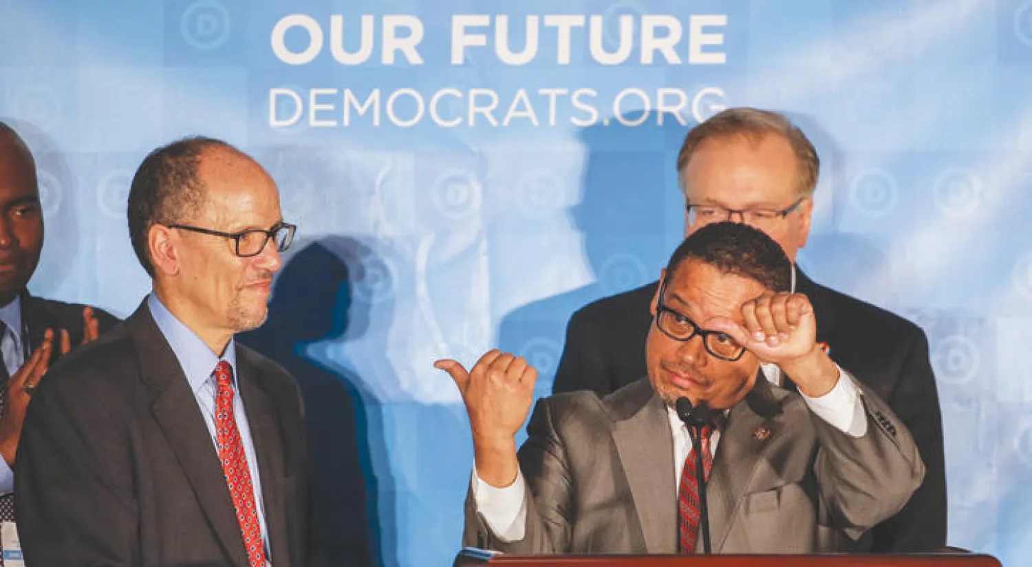 نائب رئيس اللجنة الوطنية الديمقراطية كيث إليسون يشير إلى رئيسها توم بيريز بعد الإعلان عن نتائج الانتخابات في أتلانتا بجورجيا أول من أمس (إ.ب.أ)