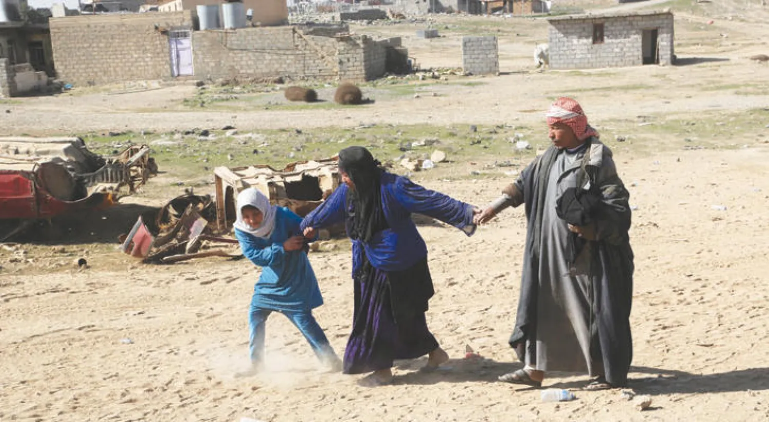 أفراد عائلة عراقية يفرون من المعارك مع «داعش» في غرب الموصل أمس (أ.ب)
