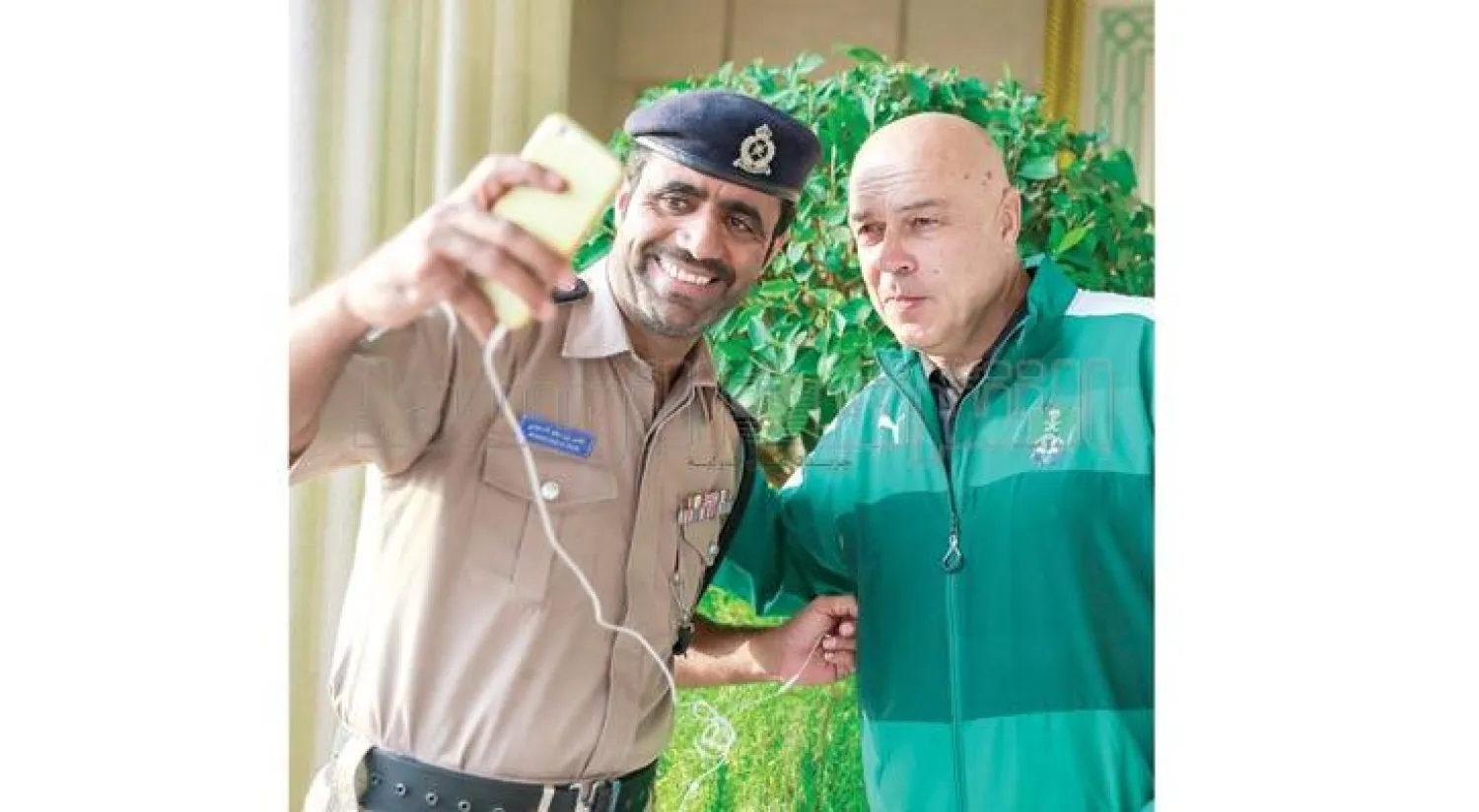 شرطي عماني يلتقط صورة مع مدرب الأهلي في مسقط (تصوير: بدر الحمد)