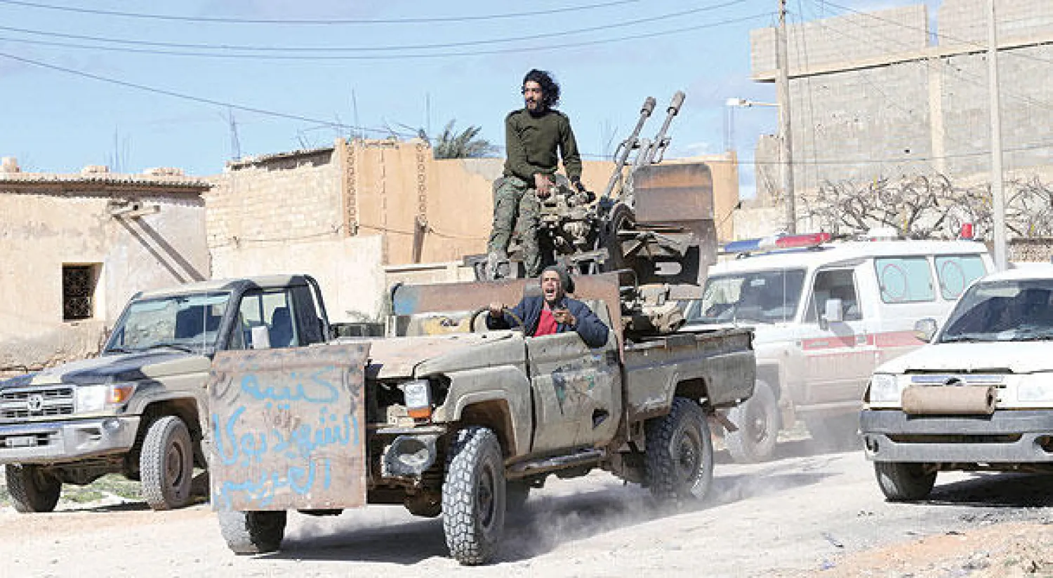 جنود ليبيون يحتفلون بعد استعادة منطقة قنفودة في مدينة بنغازي من أيدي «داعش» (رويترز)