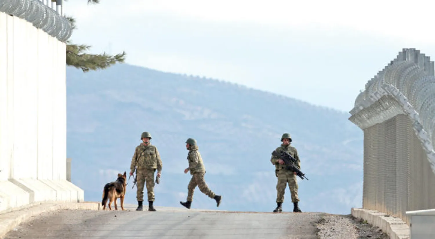دورية لجنود أتراك في كيلس أمس قرب الجدار الذي بنته تركيا على الحدود السورية العام الماضي لمنع تسلل عناصر التنظيمات المتطرفة والنازحين المدنيين (أ.ب)