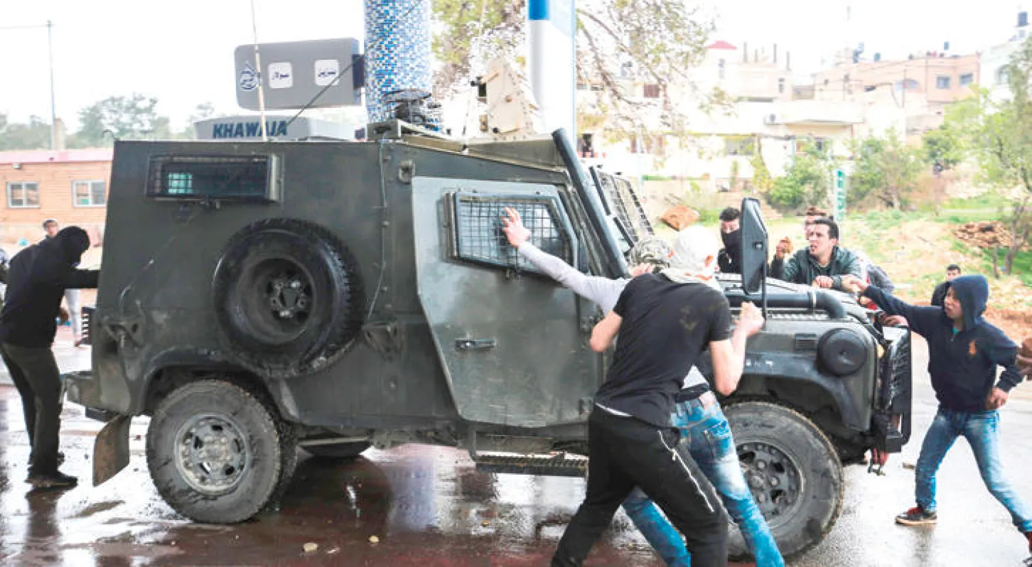 متظاهرون في قرية النبي صالح يقطعون الطريق أمام مدرعة إسرائيلية أمس (أ.ف.ب)