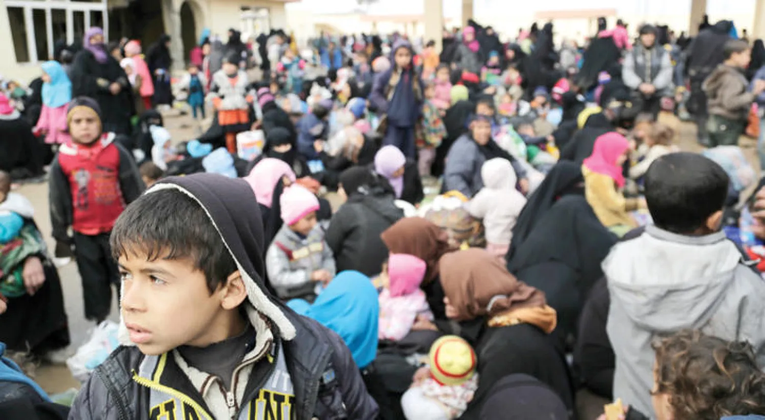 هاربون من معارك غرب الموصل يحتشدون في محطة وقود لا تعمل جنوب المدينة أمس (أ.ب)