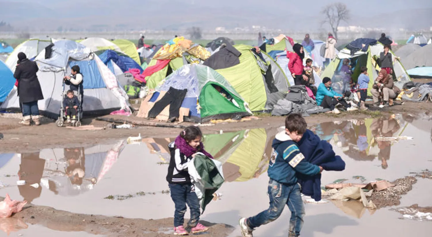 أطفال لأجئون في مخيم على الحدود اليونانية - المقدونية (أ.ف.ب)