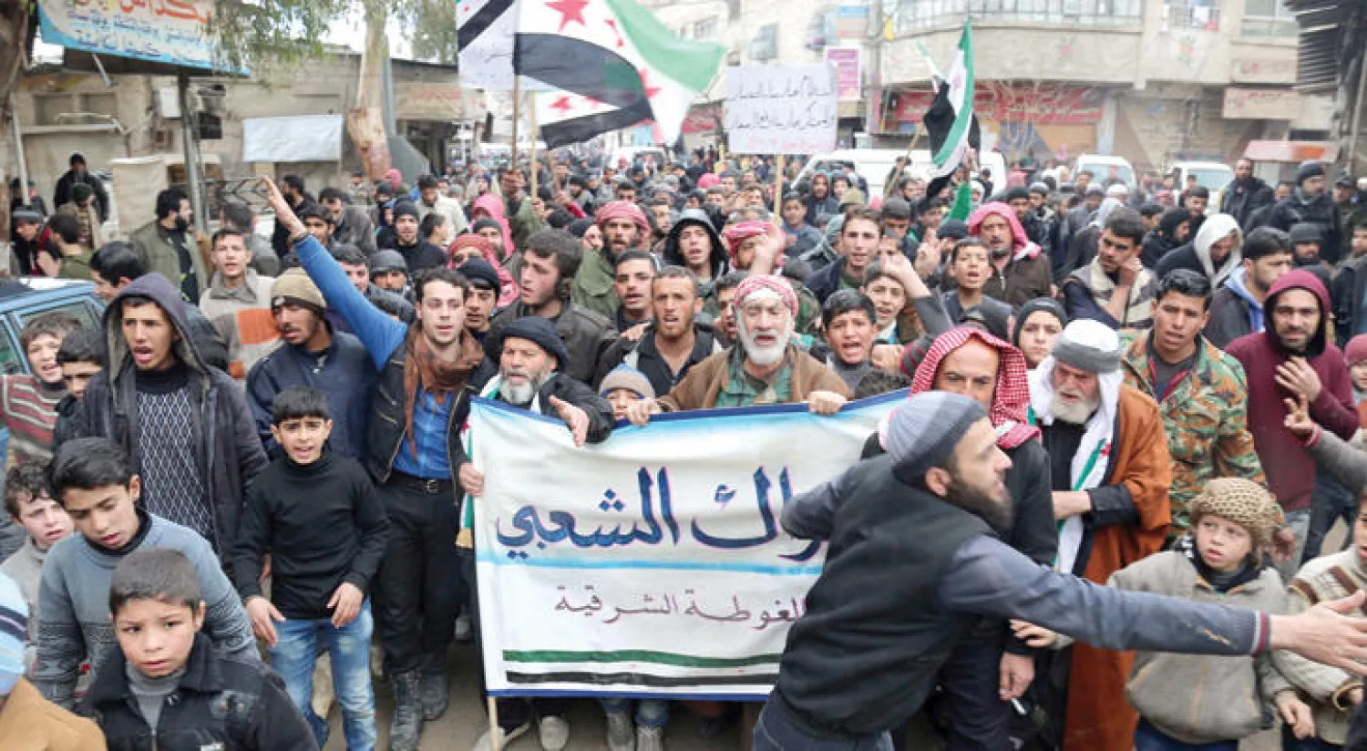 تظاهرة في مدينة دوما بضواحي دمشق احتجاجا على انتهاك نظام الأسد وفق إطلاق النار واستهدافه المدينة التي تسيطر عليها قوى المعارضة (غيتي - الأناضول)