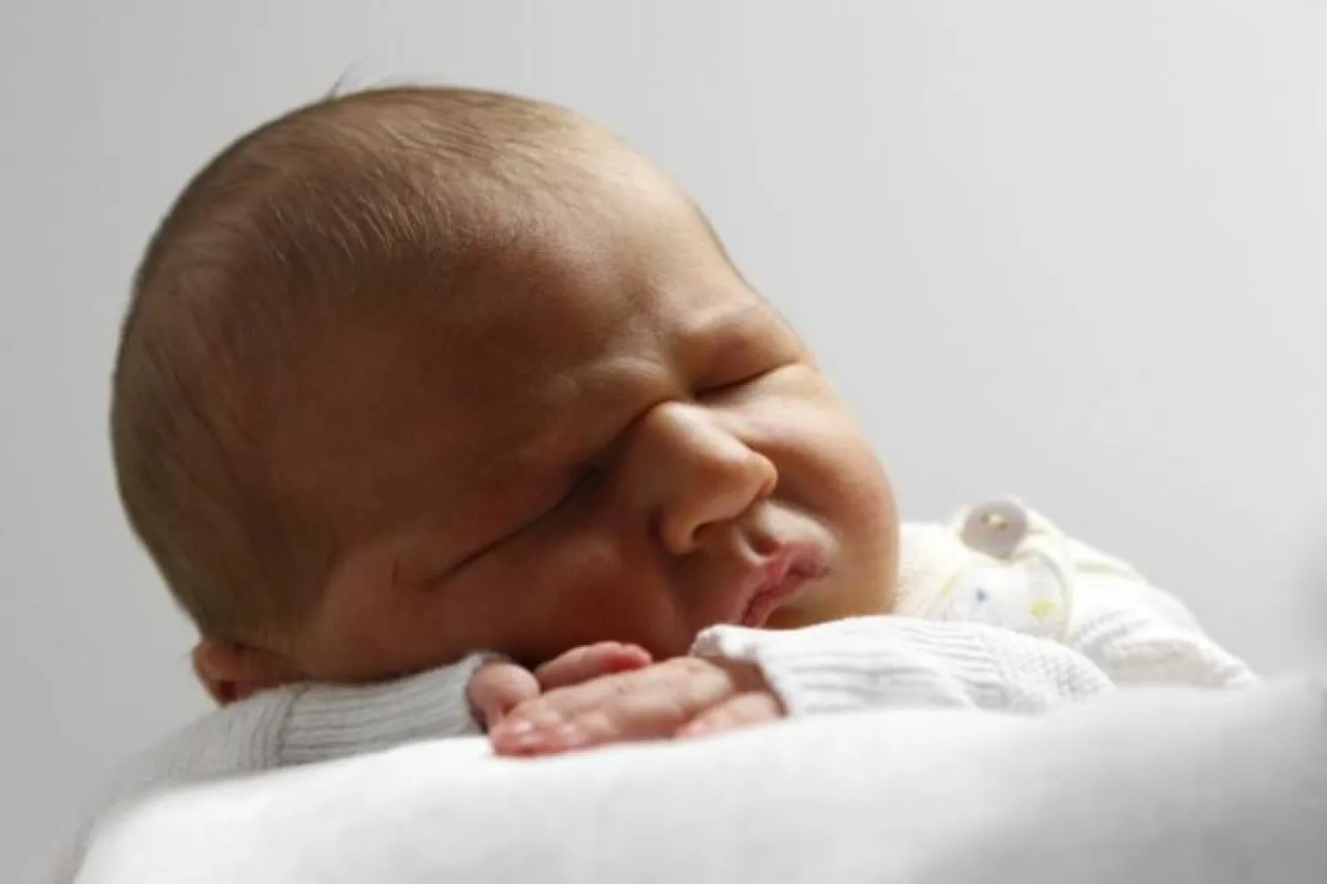 طفل صغير ينام على كتف أمه (رويترز)