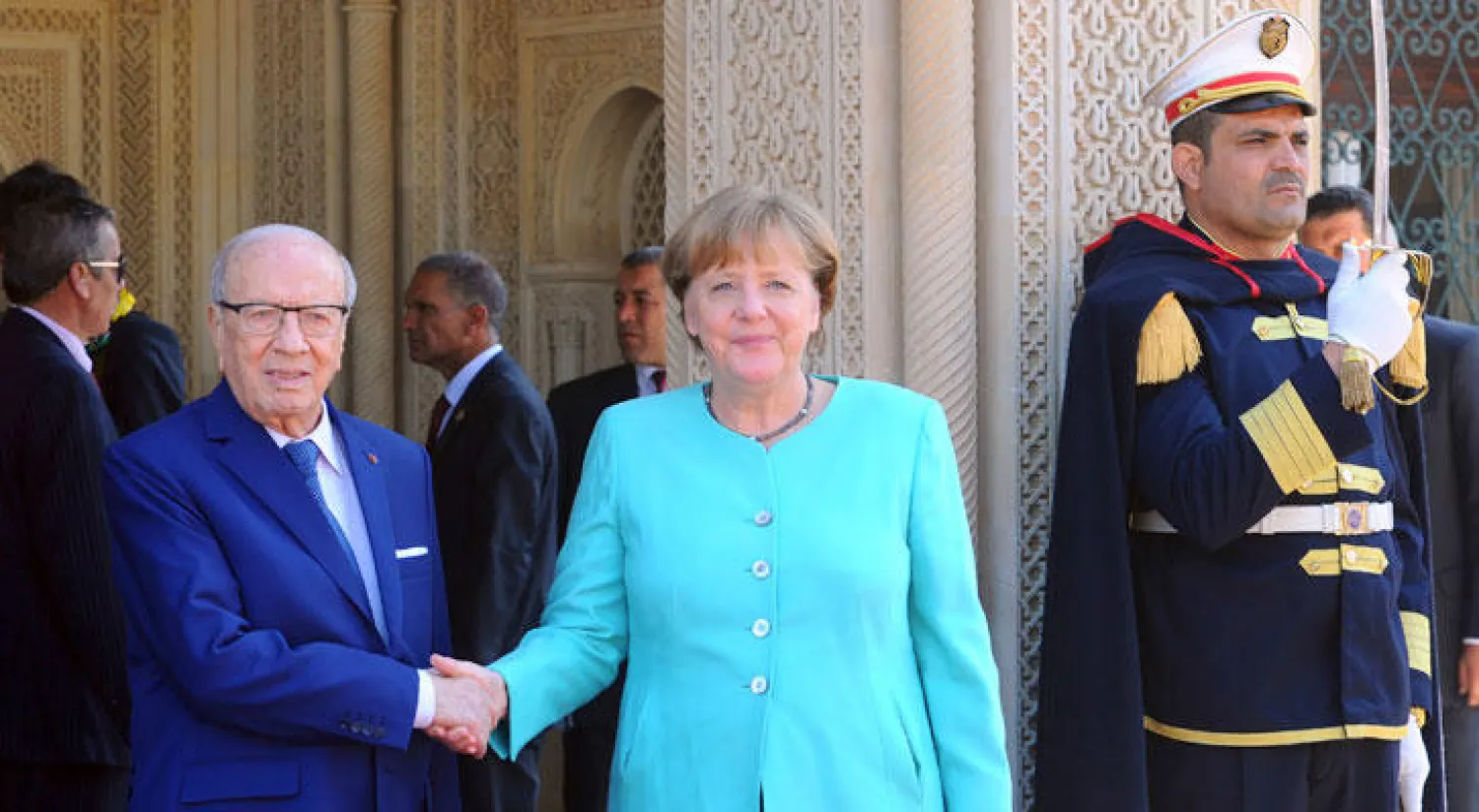 الرئيس التونسي باجي قايد السبسي يصافح المستشارة الألمانية أنغيلا ميركل قبل اجتماعهما بقصر قرطاج الرئاسي اليوم الجمعة (أ ب)