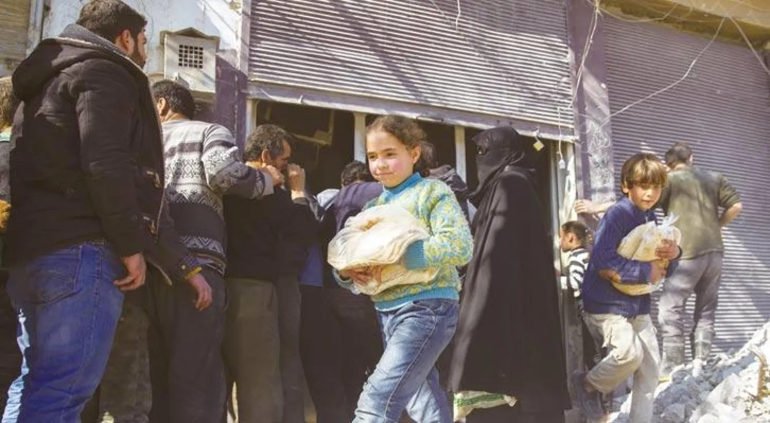 طابور أمام مخبز في مدينة الباب بالشمال السوري أمس (غيتي)