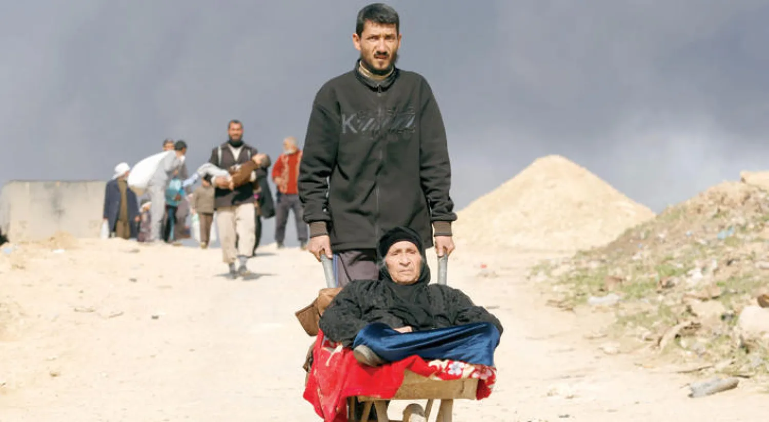 نازحون من معارك غرب الموصل يبحثون عن ملاذ آمن أمس (رويترز)