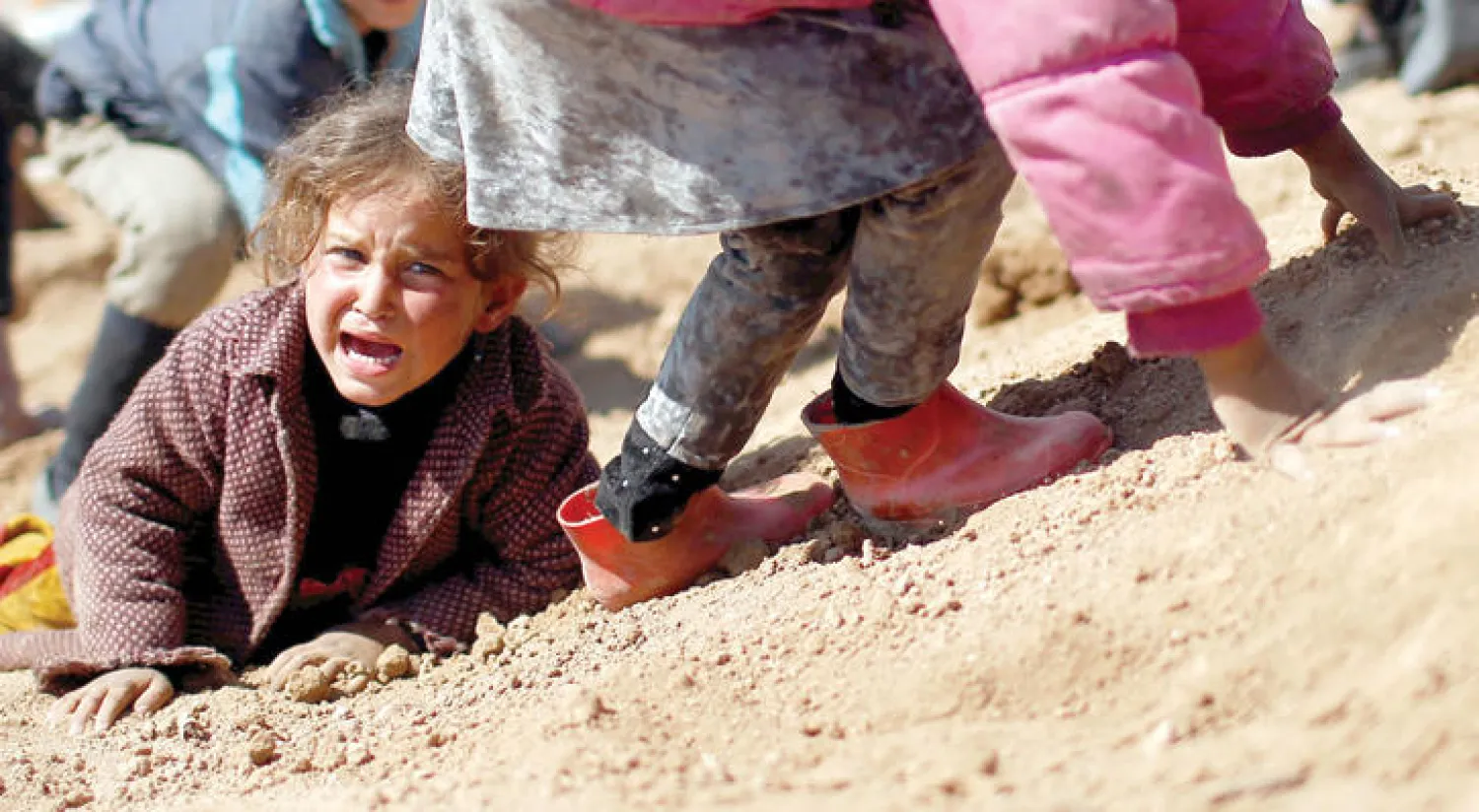 طفلة تبكي وهي تدخل إلى مخيم حمام العليل للنازحين من غرب الموصل أمس (رويترز)