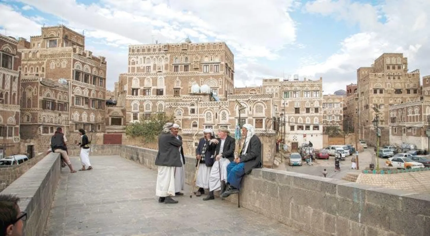 يمنيون يتبادلون الحديث قرب المدينة القديمة في صنعاء (أ.ف.ب)