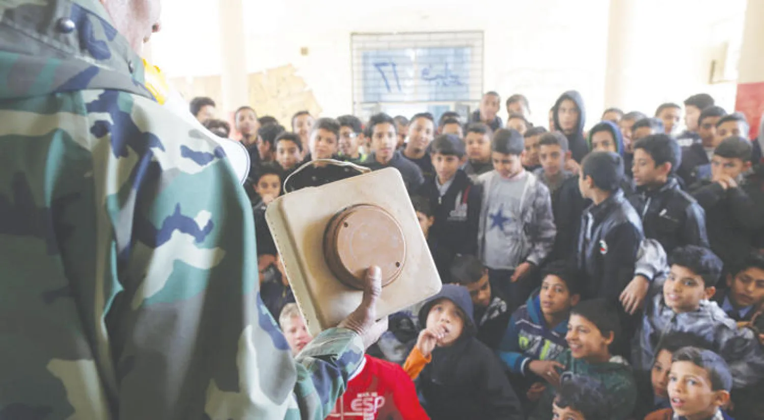 عضو في الجيش الوطني الليبي يشرح خطر الألغام والمتفجرات لتلاميذ في بنغازي الأحد (رويترز)