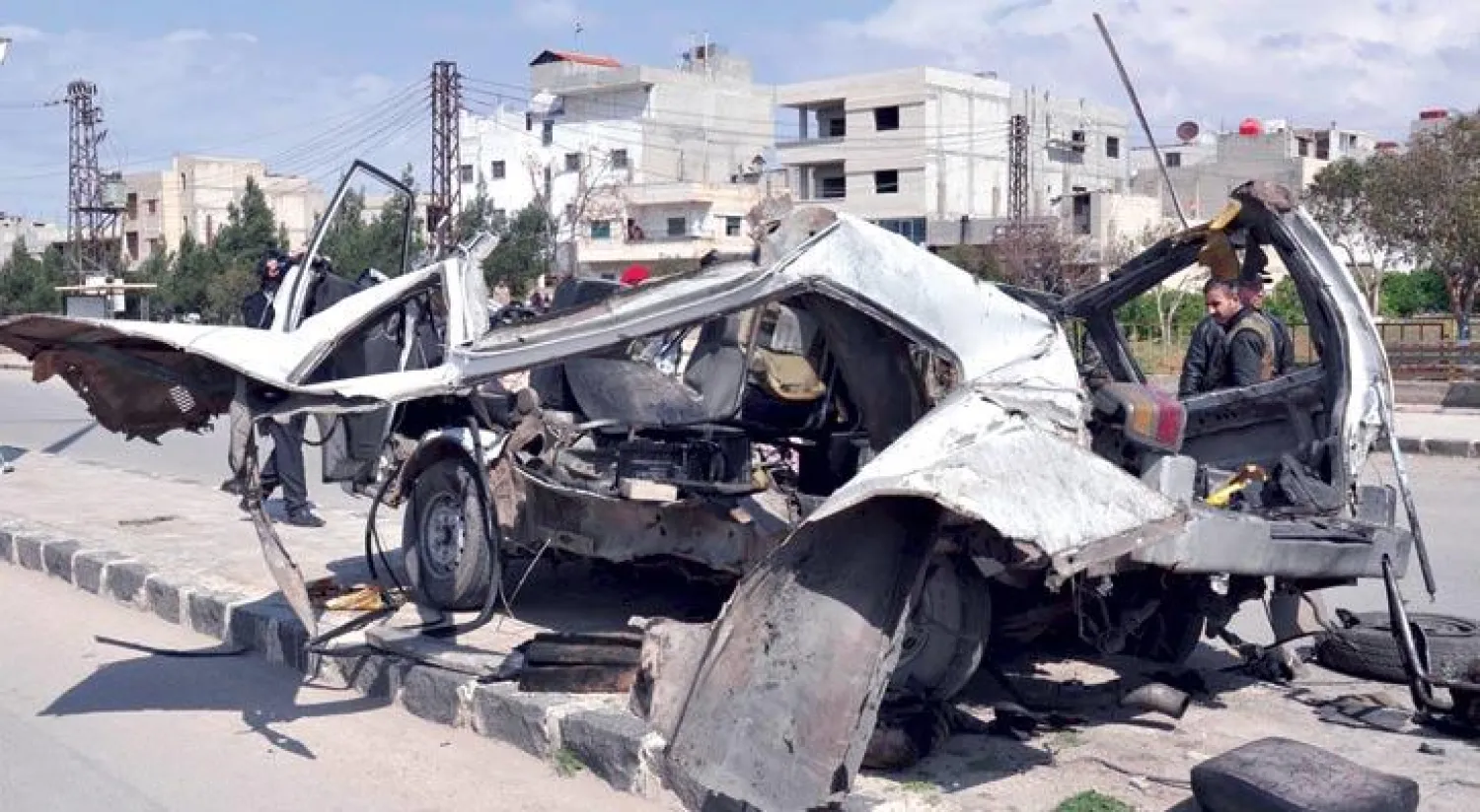 مارة يتفحصون حافلة ركاب انفجرت في وادي الذهب بمدينة حمص وسط سوريا أمس (أ.ف.ب)