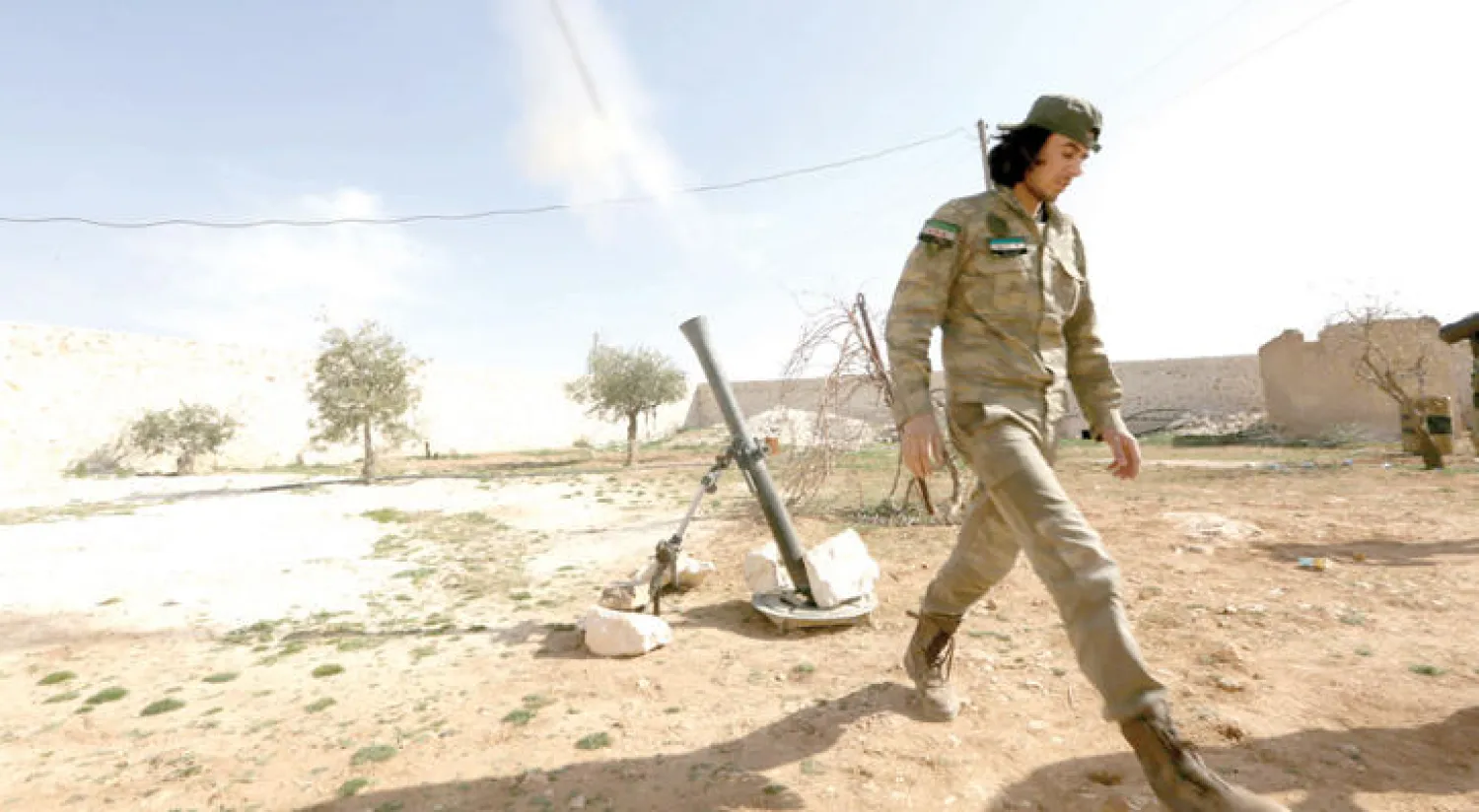 مقاتل من «درع الفرات» يطلق قذيفة «مورتر» باتجاه قوات النظام غرب مدينة منبج بريف حلب شمال سوريا (رويترز)