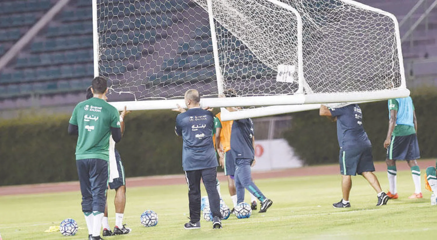 أعضاء الجهاز الفني يحملون المرمى لتجهيزه للتدريب
