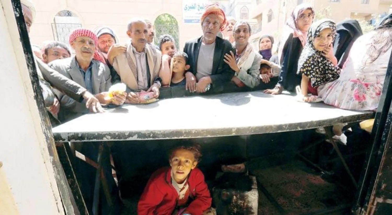 يمنيون ينتظرون حصولهم على المساعدات من إحدى منظمات العمل الخيري في صنعاء أول من أمس (إ.ب.أ)