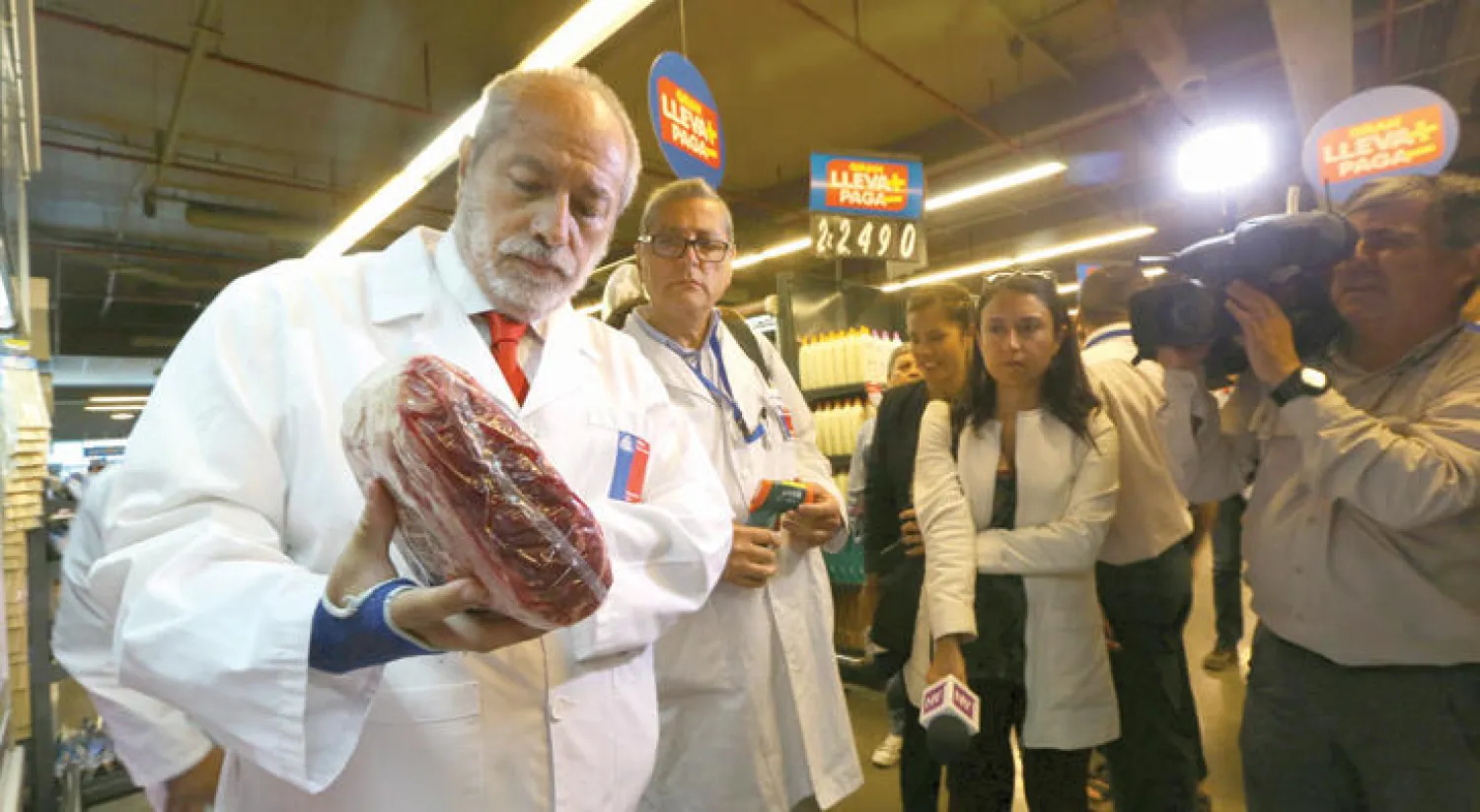 عضو من السلطات الصحية يستعرض قطعة لحم مشبوهة في متجر بتشيلي أمس (رويترز)