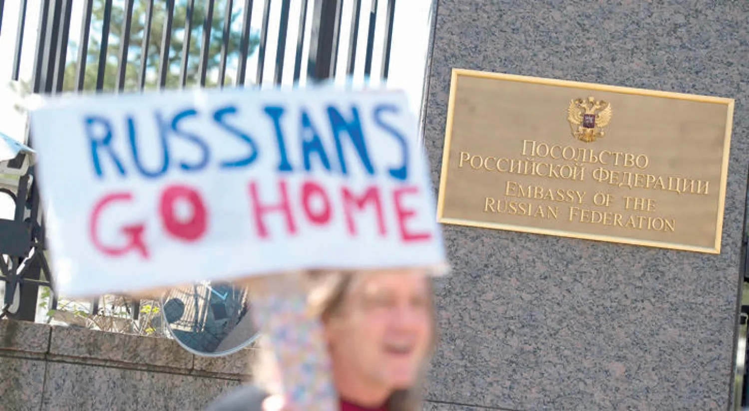 محتجون أمام السفارة الروسية في واشنطن يرفعون لافتات تخاطب موظفيها تقول «ارجعوا إلى بلدكم» (أ.ف.ب)