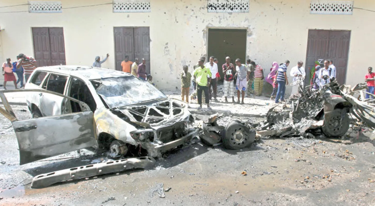 صوماليون يتجمعون بالقرب من السيارة المفخخة التي انفجرت في مقديشو أمس (أ. ب)