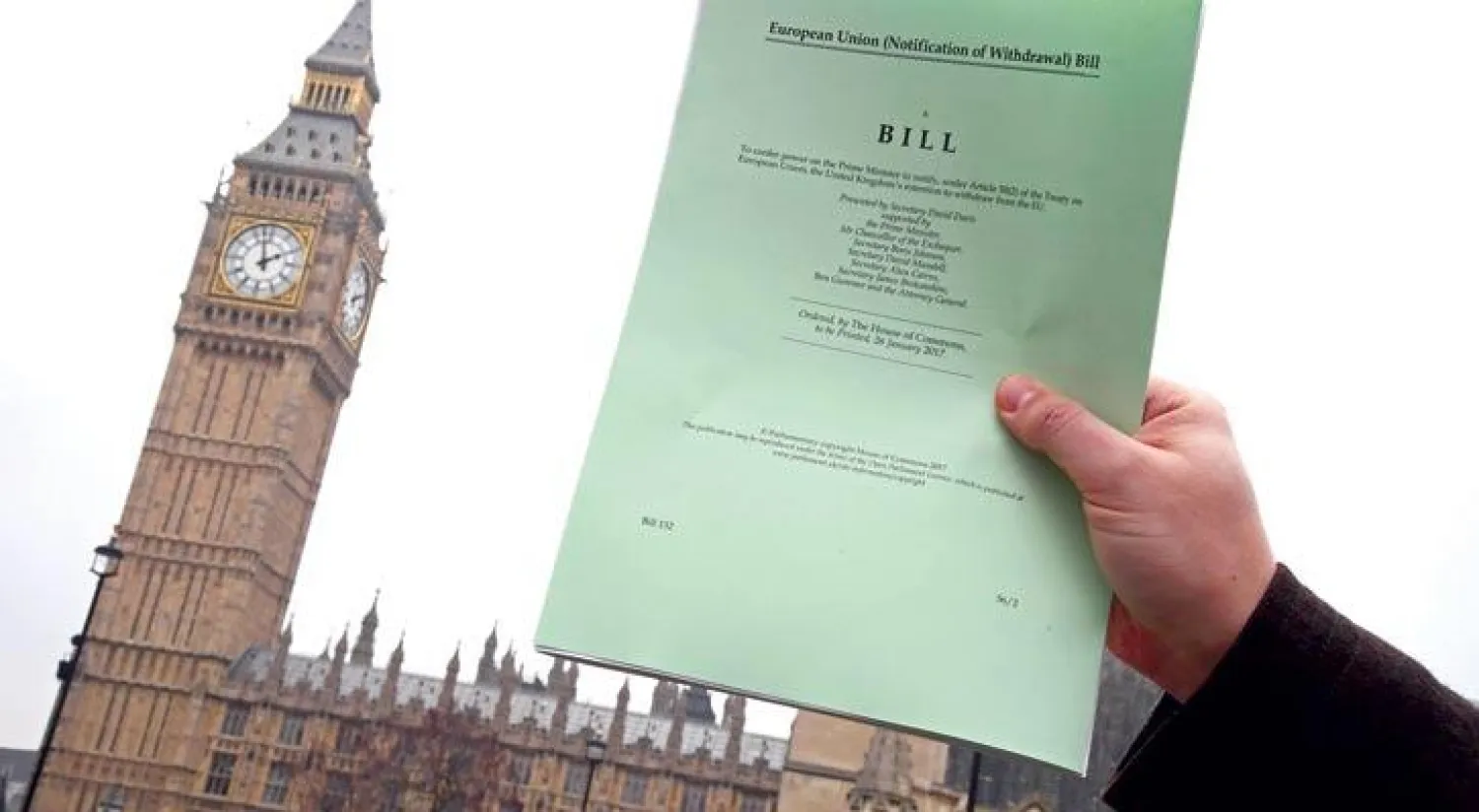 صحافي يرفع نسخة من المادة 50 من قانون خروج بريطانيا من الاتحاد الأوروبي (رويترز)