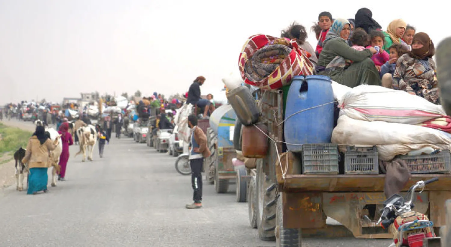 نازحون سوريون فروا من المعارك بين «داعش» و«قوات سوريا الديمقراطية» يصلون إلى قرية شمال الطبقة (أ.ف.ب)