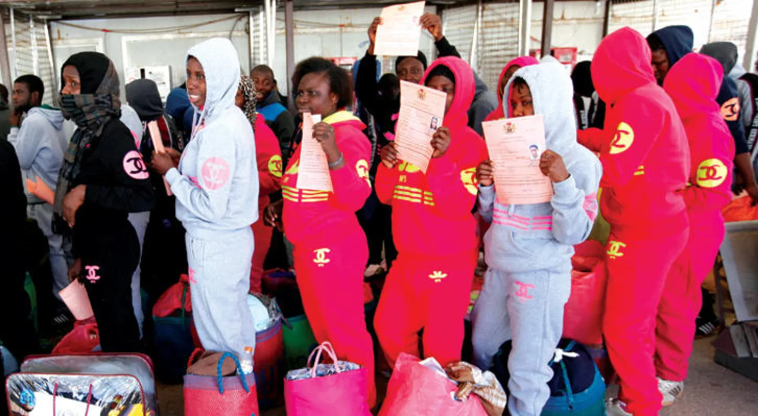 مهاجرون غير شرعيين داخل مطار معيتيقة الدولي في انتظار عودتهم الطوعية إلى بلدانهم الأصلية (رويترز)