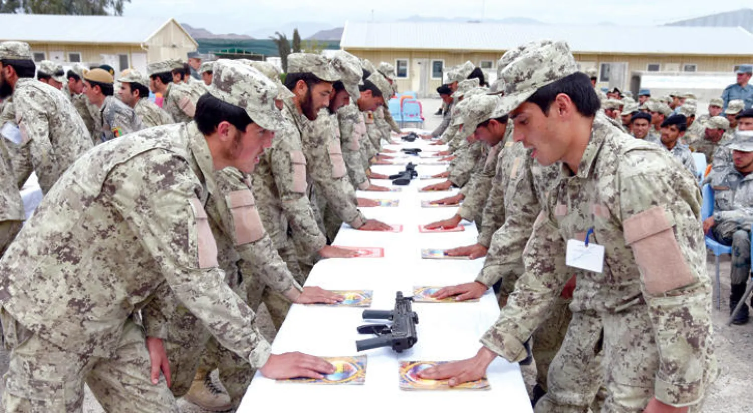 جنود أفغان يقسمون بالولاء للدولة والجيش على مصاحف خلال حفل تخرجهم قرب كابل (إ.ب.أ)