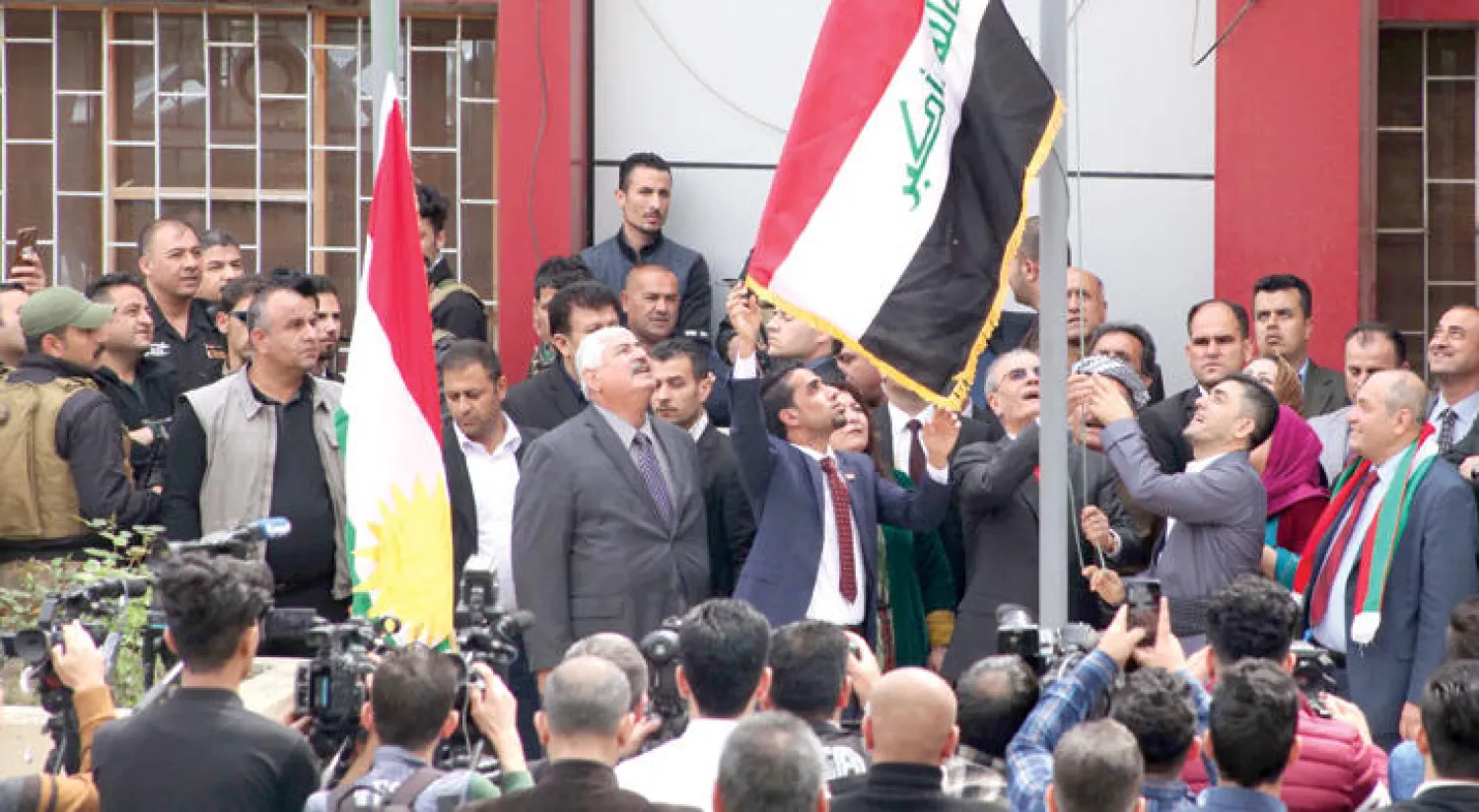 محافظ كركوك نجم الدين كريم يرفع علم كردستان إلى جانب علم العراق أمام مقر المحافظة الثلاثاء الماضي (أ.ف.ب)