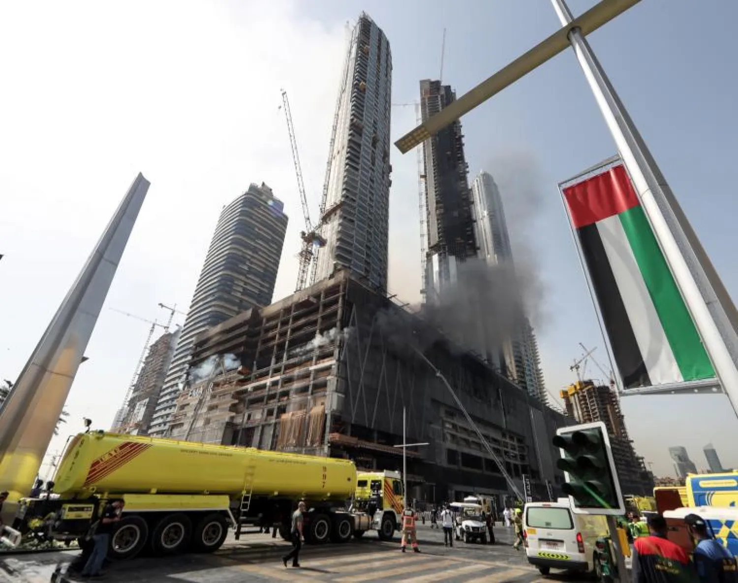 أعمدة الدخان تتصاعد في أبراج قيد الإنشاء بالقرب من برج خليفة أطول برج في العالم (أ.ف.ب)