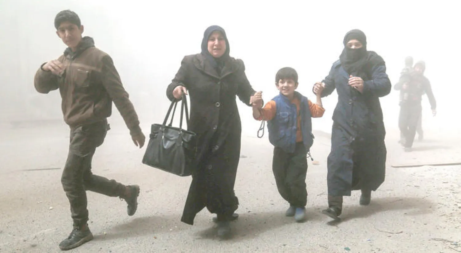 عائلة من بلدة حمورية بالغوطة الشرقية لدمشق تهرب من غارات الطيران الحربي التي طالت المنطقة أمس (أ.ف.ب)