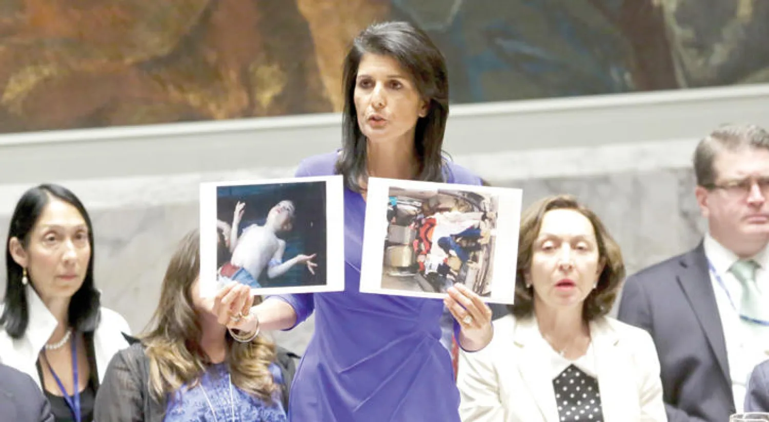 السفيرة الأميركية نيكي هايلي تعرض صورتين لضحايا الهجوم الكيماوي على إدلب خلال جلسة مجلس الأمن أمس (أ.ب)