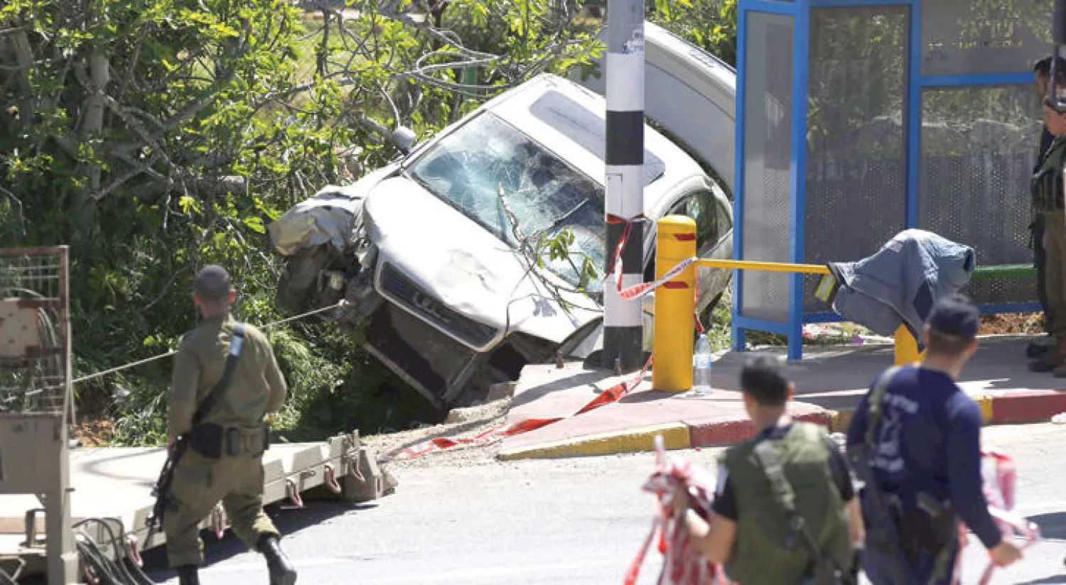 عناصر أمن قرب موقع هجوم نفذه شاب فلسطيني قتل جندياً إسرائيلياً دهساً وجرح آخر أمام مستوطنة عوفرا شمال رام الله أمس (أ.ف.ب)