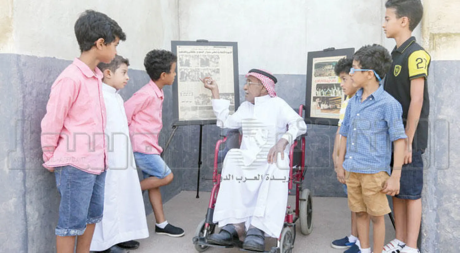 أطفال يستمعون لشرح من أحد المشجعين القدامى للاتحاد في متحف النادي أمس (تصوير: محمد المانع)
