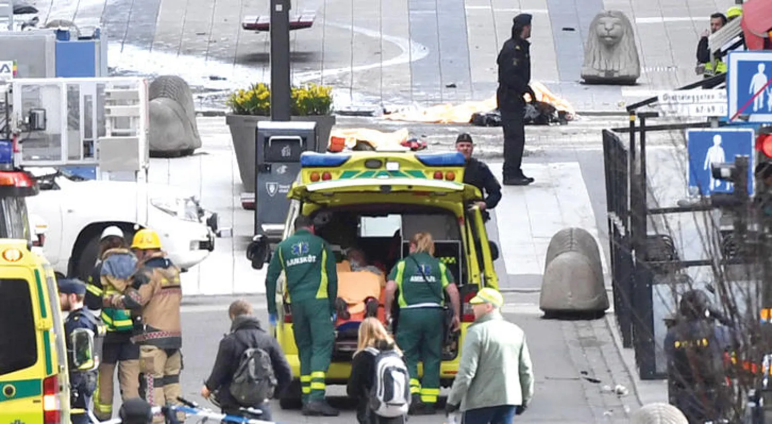 رجال الشرطة والإسعاف والإنقاذ في الشارع التجاري الذي تعرض لحادث دهس متعمد بوسط استوكهولم أمس (أ.ف.ب)