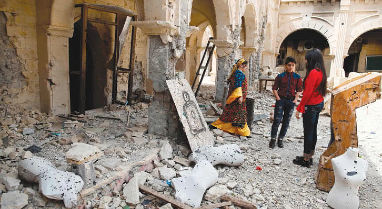 مسيحيون يعاينون الدمار في كنيسة قرقوش حيث أقيم قداس «أحد الشعانين» أمس (أ.ف.ب)