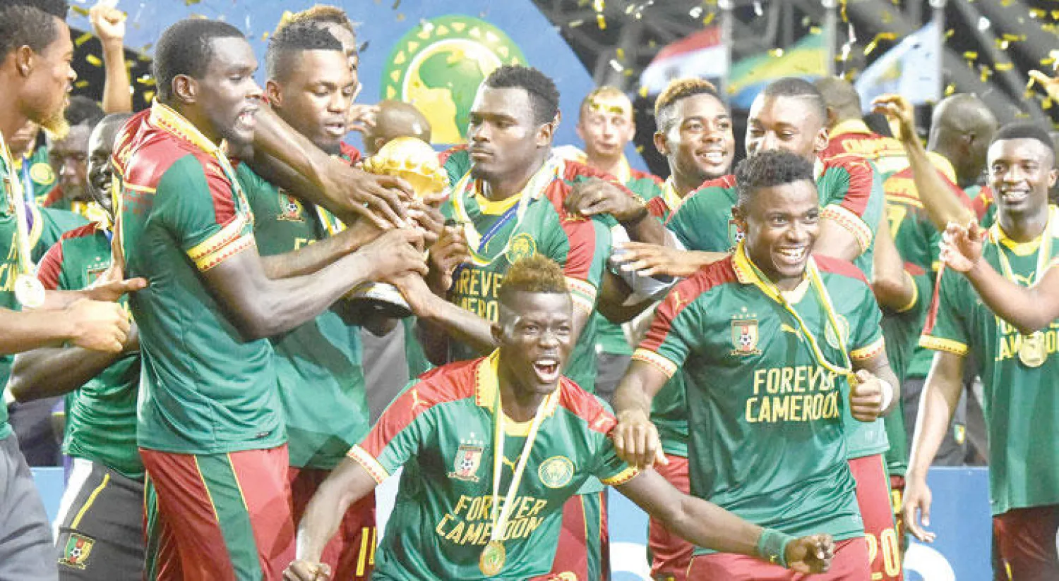كريستيان باسوغوغ يتوسط لاعبي الكاميرون بعد الفوز بكأس الأمم الأفريقية (أ.ف.ب)