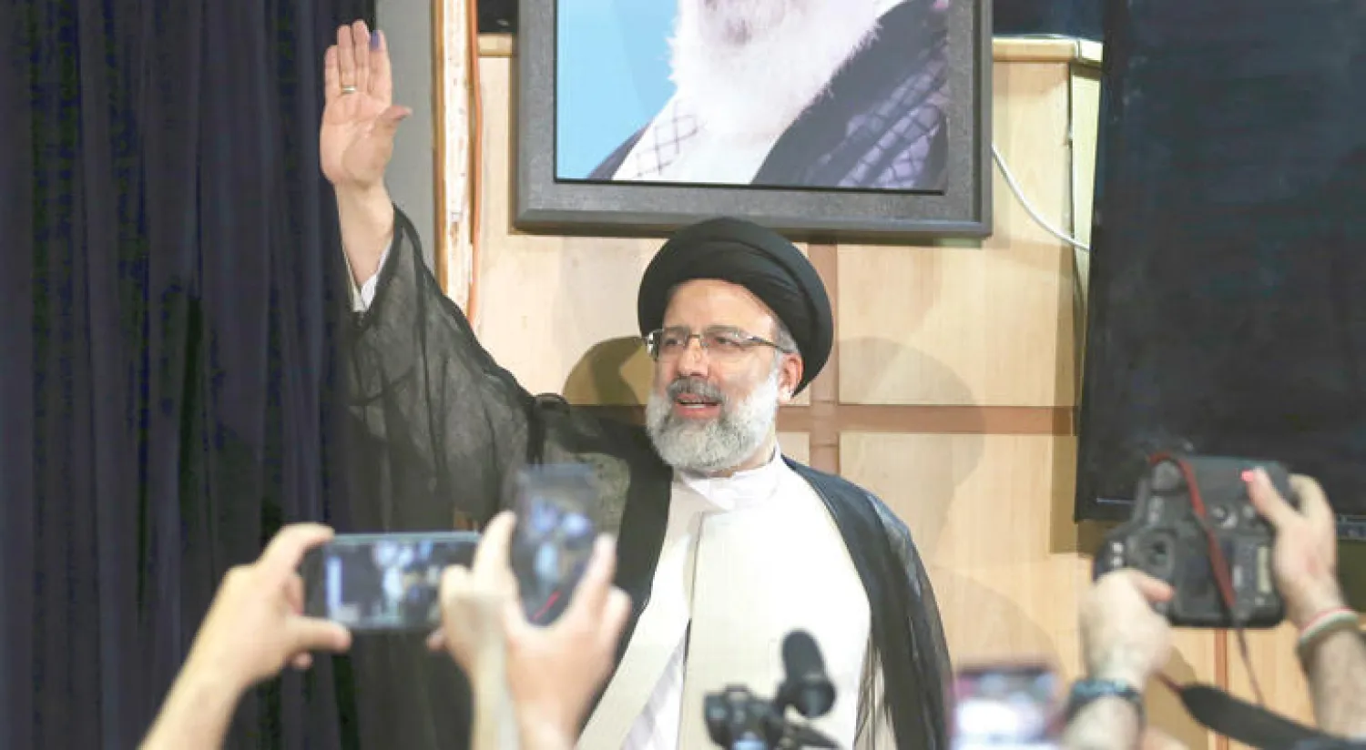 رئيسي يلوح لوسائل الإعلام بعد تقديمه طلب ترشحه أمس (أ.ب)