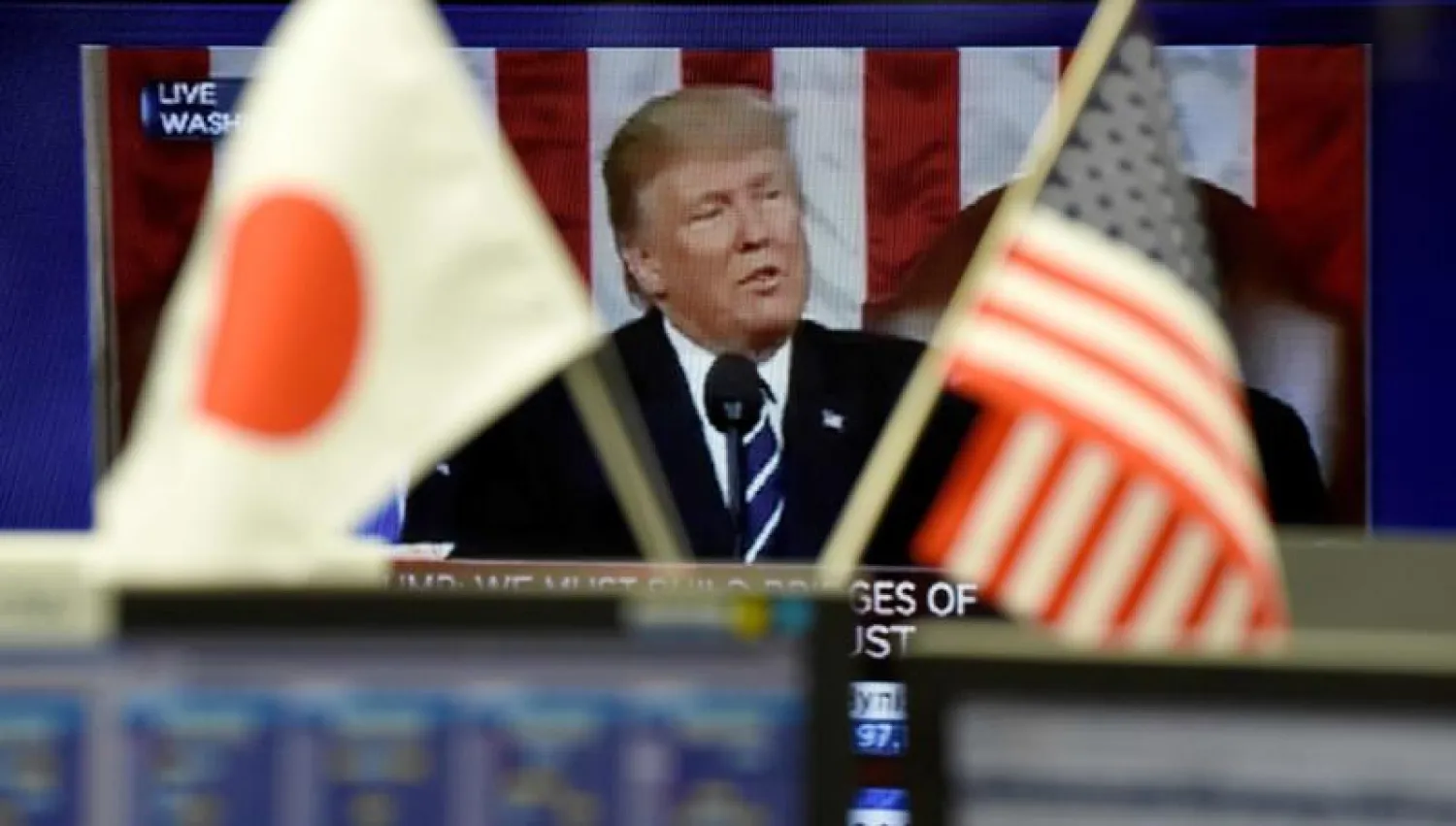 شاشة تعرض خطاباً للرئيس ترمب في سوق مالية بطوكيو (أ.ف.ب)