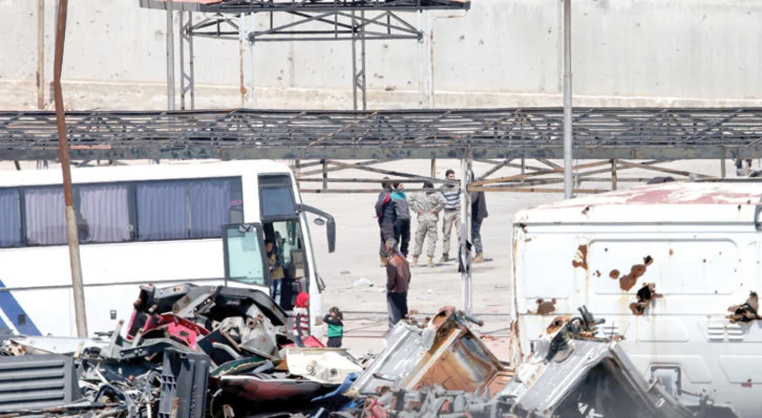 مقاتلون من بلدة الزبداني قرب دمشق ينتظرون في الراموسة بحلب أمس استكمال إجراءات نقلهم بحسب اتفاق البلدات السورية الأربع الذي تعطل أكثر من مرة (أ.ف.ب)