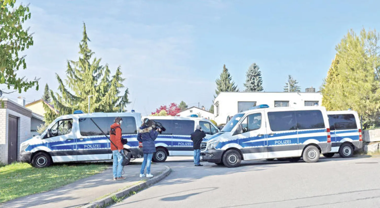 سيارات الشرطة الألمانية وبعض ممثلي وسائل الإعلام أمام منزل المشتبه به الذي يحمل الجنسيتين الألمانية والروسية  (إ.ب.أ)