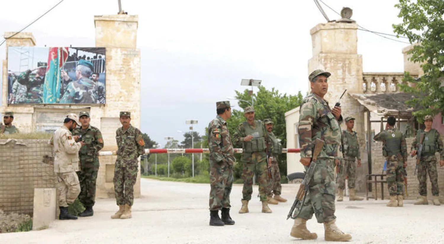 عناصر في الجيش الوطني الأفغاني يحرسون مدخل القاعدة العسكرية في مزار شريف التي تعرضت لهجوم أمس (رويترز)