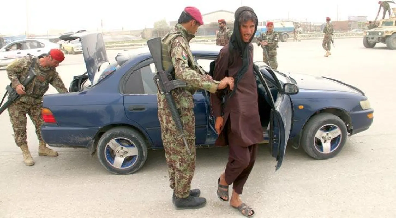 تفتيش ركاب وإجراءات أمنية مشددة على الطريق السريع خارج غزني عقب هجوم طالبان على القاعدة العسكرية في مزار شريف ومقتل أكثر من 140 جندياً أول من أمس (إ.ب.أ)