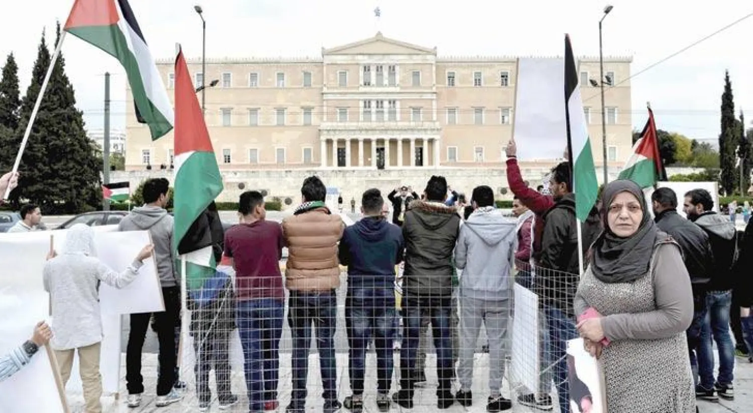 فلسطينيون مهاجرون في اليونان يشاركون في مظاهرة أمام البرلمان اليوناني في أثينا تضامناً مع إضراب الأسرى الفلسطينيين (أ.ف.ب)