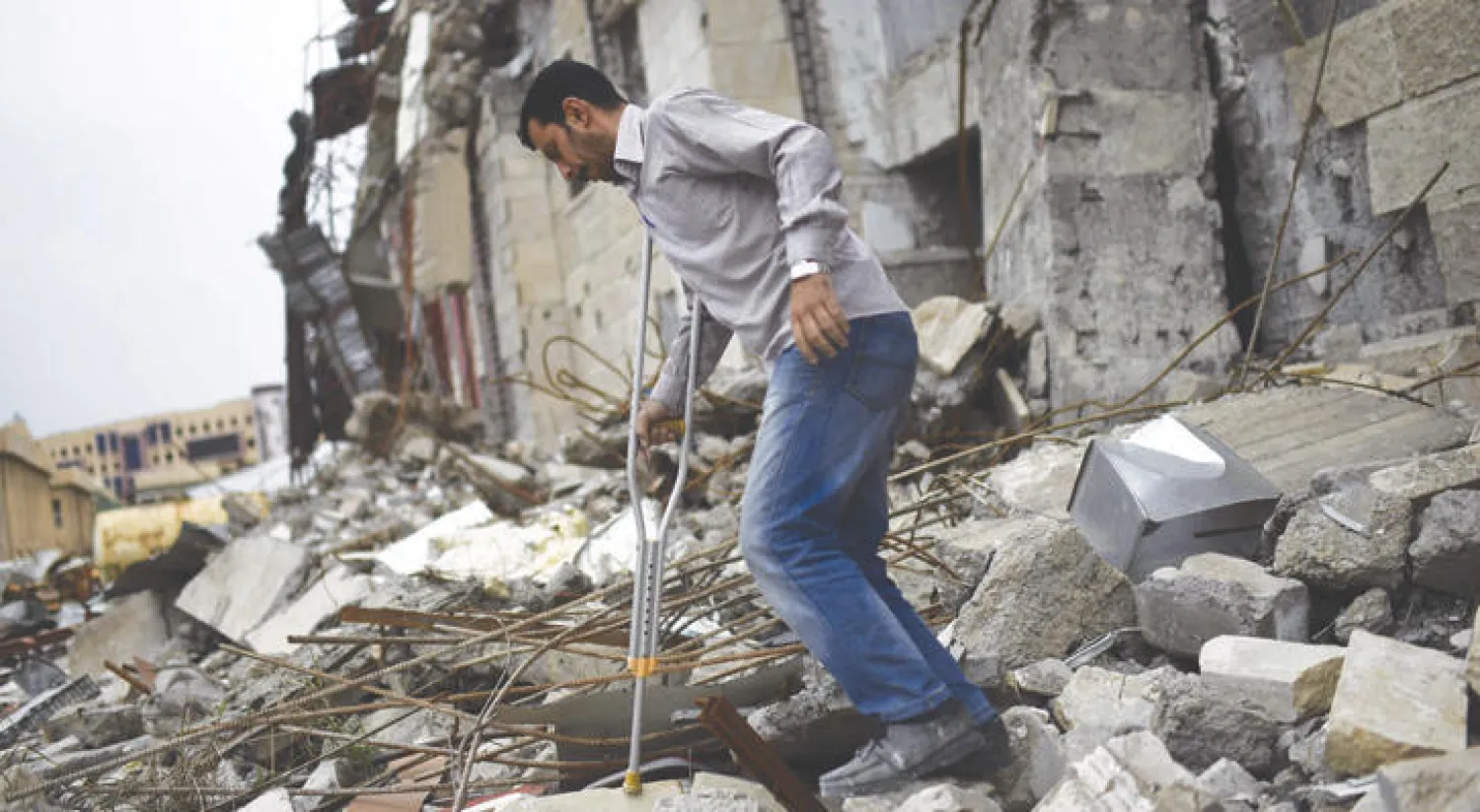 المتطوع نزار يمشي فوق أنقاض مبان مدمرة في جامعة الموصل (أ.ف.ب)