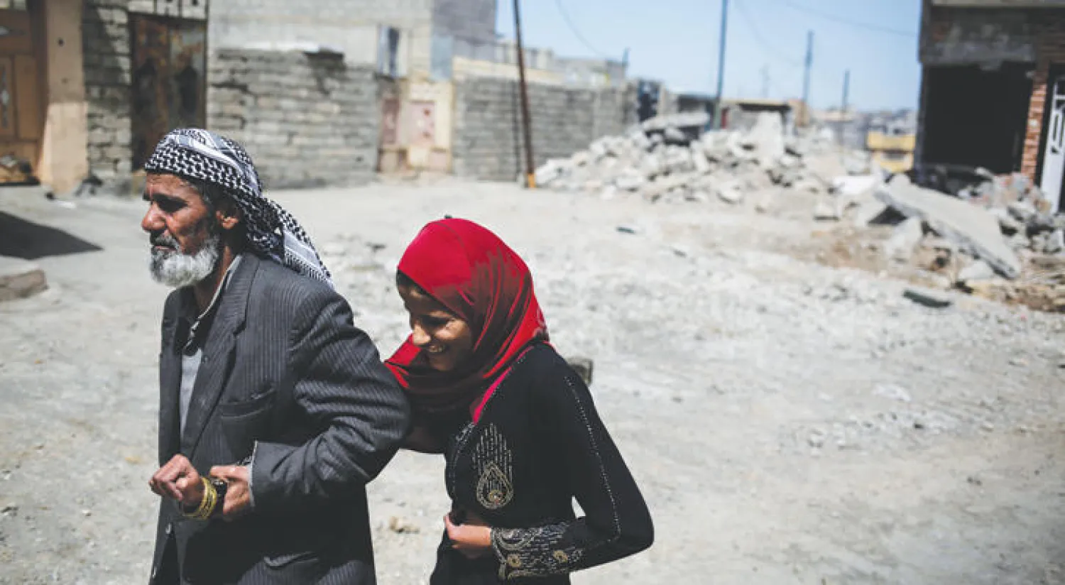 مدنيان يفران من المعارك في أحد أحياء غرب الموصل (أ.ب)