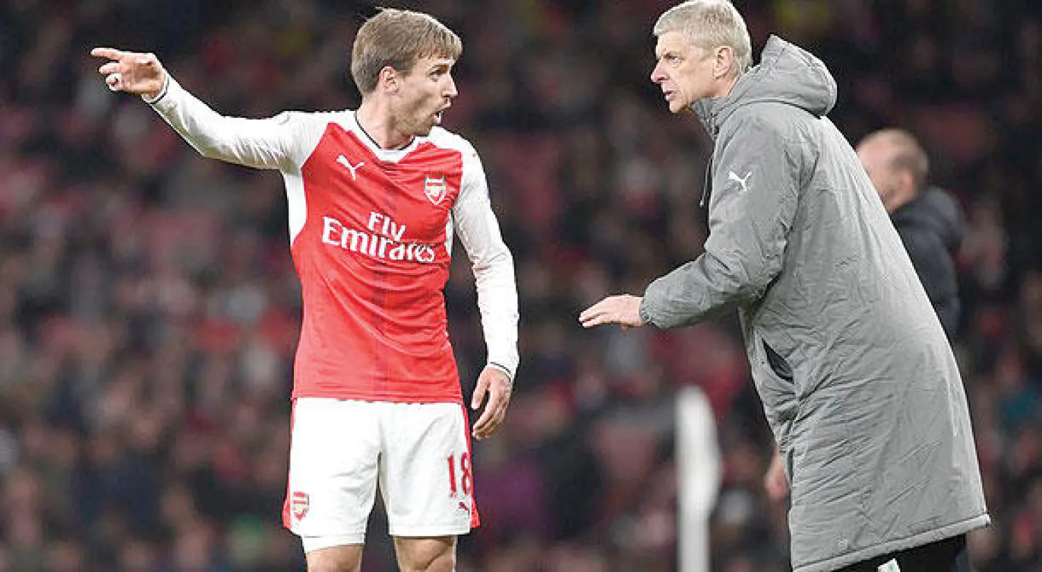 فينغر يعطي تعليماته لمونريال الذي كان ضمن ثلاثي خط الدفاع  في المباراة التي فاز فيها آرسنال على ليستر الأربعاء